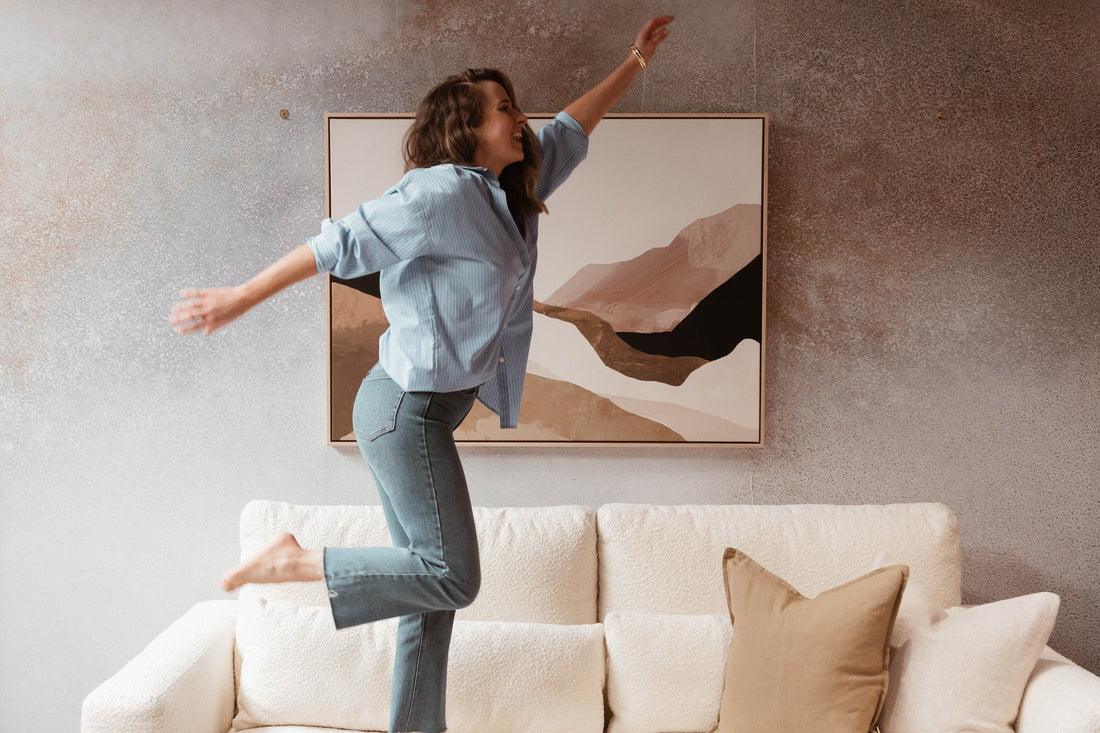 a girl jumping on a sofa