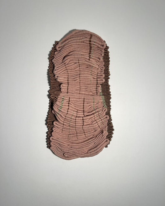 Hand-knotted textile wall art in blush tones with metallic thread detail