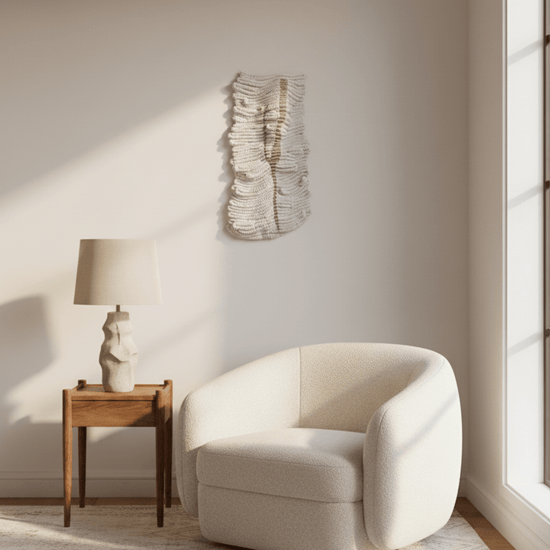 Neutral textured fibre wall art in a minimalist reading corner