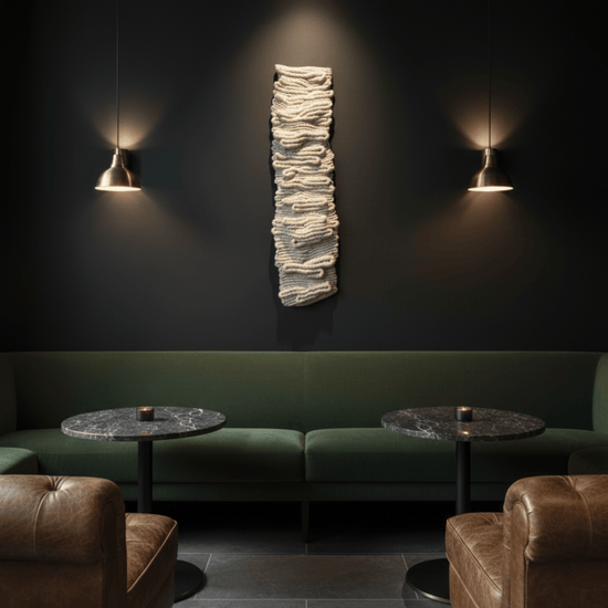 Vertical neutral textile wall art in a moody restaurant interior