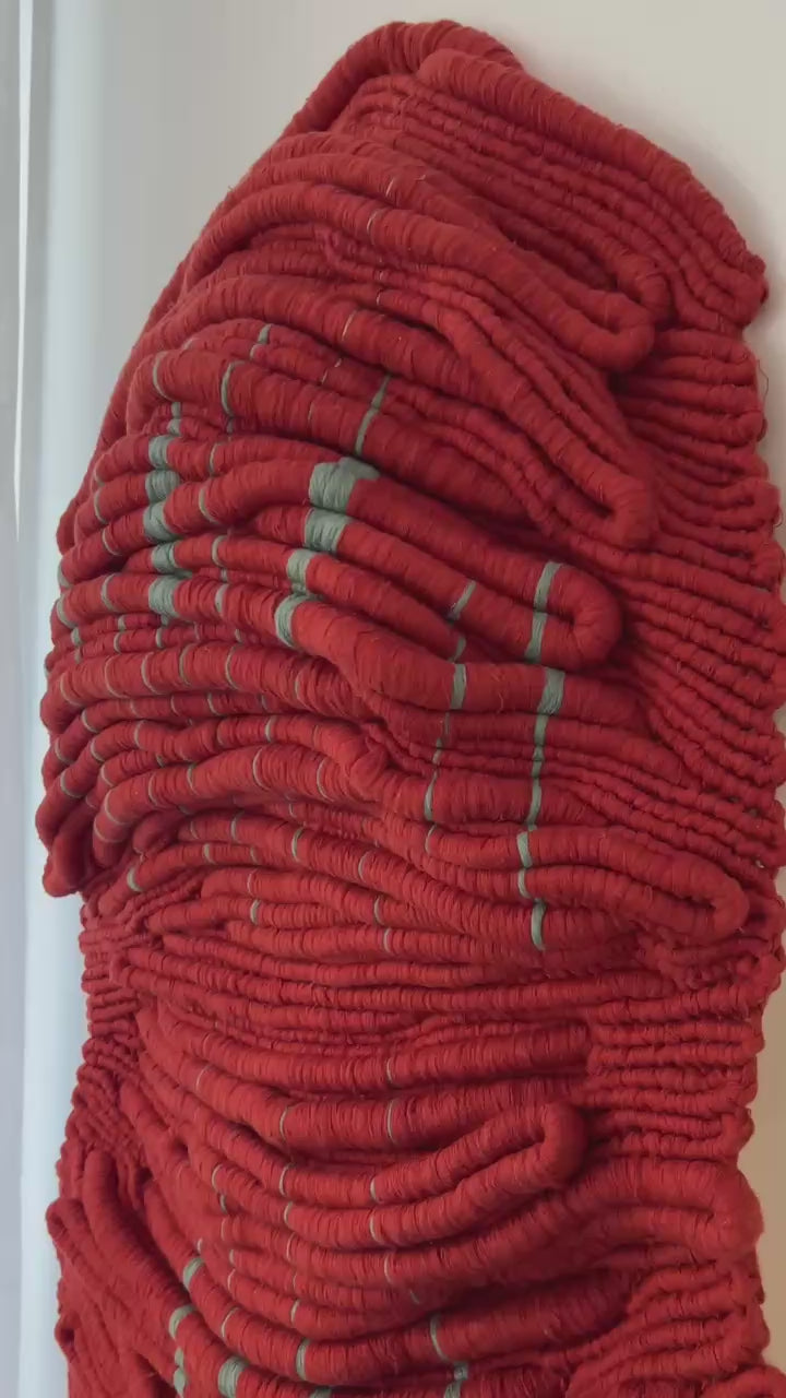 Video detail of Wounded Healer, a red hand-knotted sculptural textile artwork by Melbourne fibre artist Kasia Dudkiewicz, showing its tactile depth and relief.