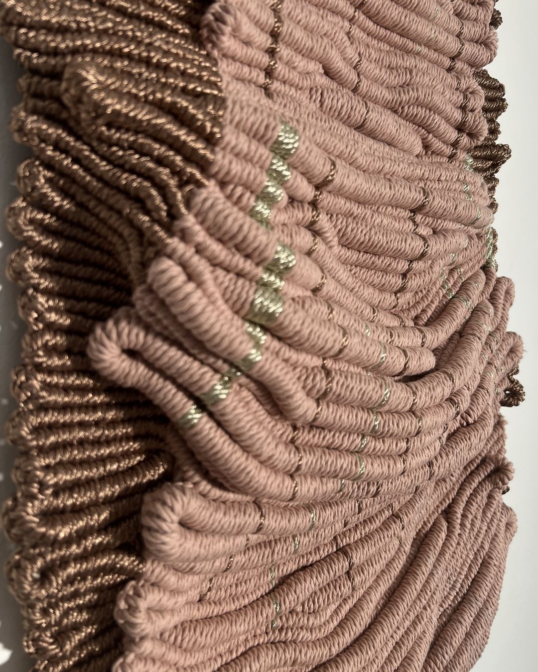 Dimensional rope wall art in blush and gold adding warmth and texture
