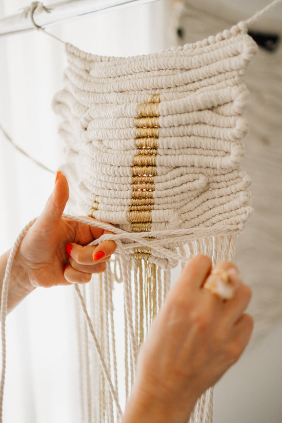 work in progress on a sculptural fibre wall art, natural  and gold tones, knotted by hand